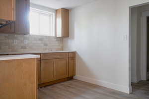 Kitchen with backsplash and light wood-style flooring