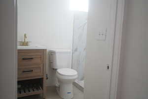 Bathroom featuring vanity, light tile patterned floors, and a marble finish shower