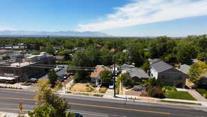 Aerial perspective of suburban area with mountains and a heavily wooded area