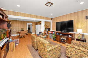 Living area with wood finished floors, wooden walls, and recessed lighting