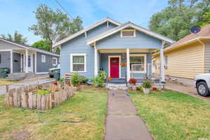 View of front of home with covered porch and a front lawn