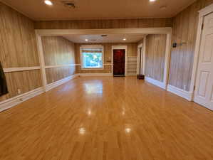 Empty room featuring wood walls and wood finished floors