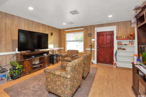 Living room with wood finished floors and wooden walls