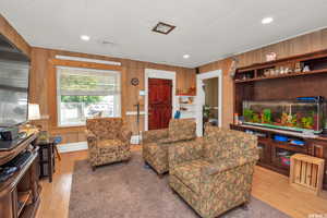 Living area featuring wood walls, light wood-type flooring, and recessed lighting