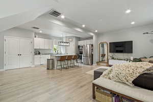 Living area with light wood-type flooring and recessed lighting