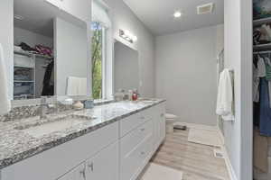 Full bathroom with a walk in closet, a shower stall, and light wood-type flooring