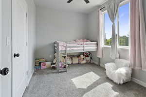 Carpeted bedroom with a ceiling fan and a closet