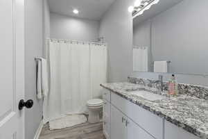 Full bathroom featuring vanity and light wood-style flooring