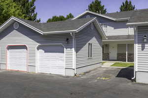 View of front of home featuring a garage and roof with shingles