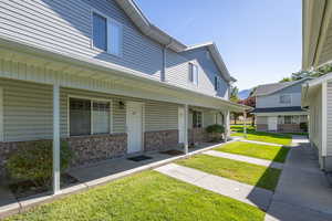 View of front of property featuring covered porch, brick siding, and a front yard