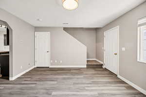 Below grade area with arched walkways and light wood-style floors