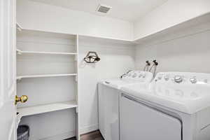 Laundry area featuring washing machine and clothes dryer and dark wood finished floors