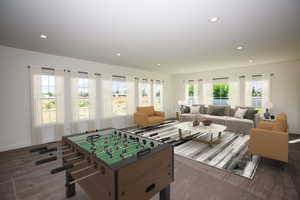 Spacious recreation/family room (lots of options) featuring recessed lighting and dark carpet with natural light - Virtual Staging