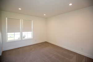 Bedroom featuring ensuite full bathroom, recessed lighting and dark colored carpet