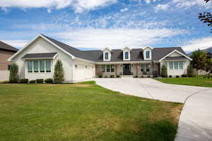 View of front of house featuring a covered porch, a front yard, driveway, a garage, and board and batten siding