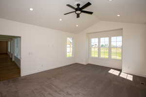 Master suite featuring lofted ceiling, dark carpet, recessed lighting, and ceiling fan