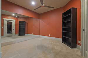 Empty room with carpet floors and a ceiling fan