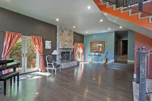 Living room featuring stairway, french doors, wood finished floors, a textured ceiling, and recessed lighting