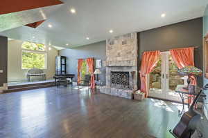 Living room featuring healthy amount of natural light, hardwood / wood-style flooring, a fireplace, recessed lighting, and french doors