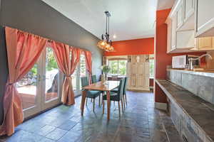 Dining room featuring stone tile flooring, a textured ceiling, and french doors