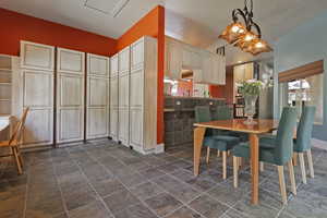 Dining space with dark stone finish flooring and baseboards