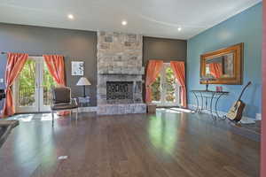 Living room featuring french doors, wood finished floors, a fireplace, and recessed lighting