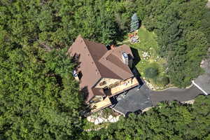 Aerial view of property and surrounding area with a heavily wooded area