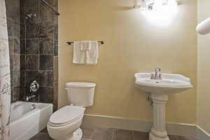 Bathroom featuring shower / tub combo with curtain and tile patterned floors