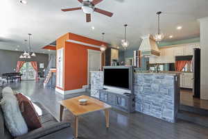 Living room featuring a chandelier, stairway, dark wood-style flooring, recessed lighting, and french doors
