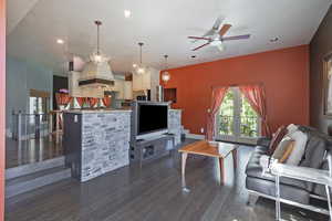 Living room featuring dark wood-type flooring, ceiling fan, recessed lighting, a textured ceiling, and french doors