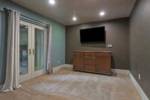 Living area featuring french doors, light colored carpet, and recessed lighting