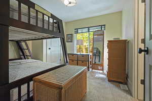Bedroom with light colored carpet and a textured ceiling