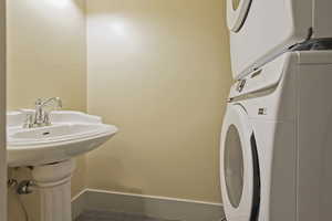 Laundry room with stacked washer / dryer and baseboards