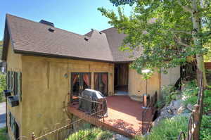 Rear view of property featuring roof with shingles and a wooden deck