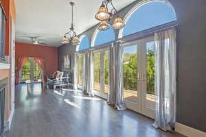 Interior space with french doors, dark wood-style floors, a ceiling fan, and a high ceiling