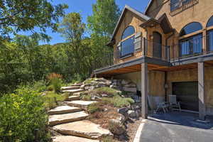 View of home's exterior with an attached garage and a wooded view