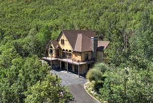 Aerial view of property and surrounding area with a heavily wooded area