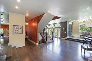 Living area with stairway, dark wood-type flooring, a textured ceiling, and recessed lighting