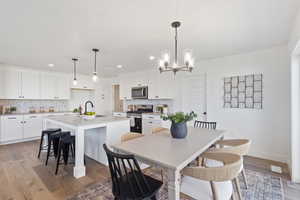 Dining area featuring light wood-style flooring, a chandelier, and recessed lighting