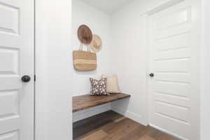 Mudroom featuring dark wood-type flooring and baseboards