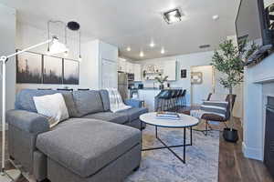 Living area with dark wood-style floors, a fireplace, and a textured ceiling