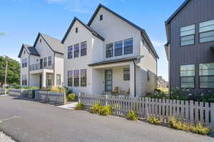 Modern inspired farmhouse featuring a fenced front yard and covered porch