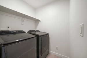 Washroom with baseboards and washer and clothes dryer