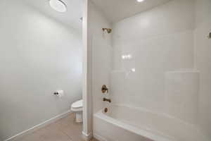 Full bath featuring light tile patterned floors and bathing tub / shower combination