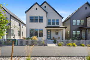 View of front of property with covered porch and a fenced front yard