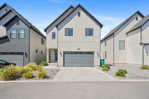 Modern farmhouse featuring concrete driveway and a garage