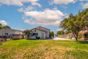 Rear view of the house and garage with an over sized fully fenced back yard.