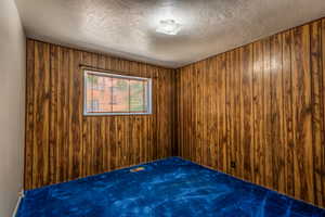 Bedroom #2 Carpeted room with wood panel walls and a textured ceiling