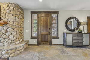 Foyer entrance featuring stone flooring and baseboards