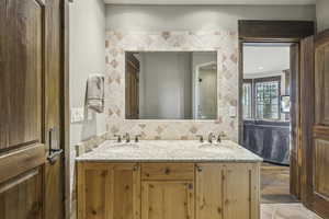 Bathroom with double vanity, tasteful backsplash, and ensuite bathroom